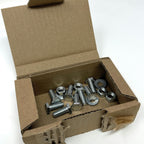Open cardboard box filled with metal screws on a white background